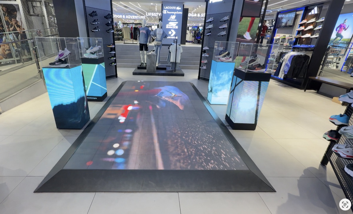 Sol LED et présentoirs de produits dans un magasin de sport